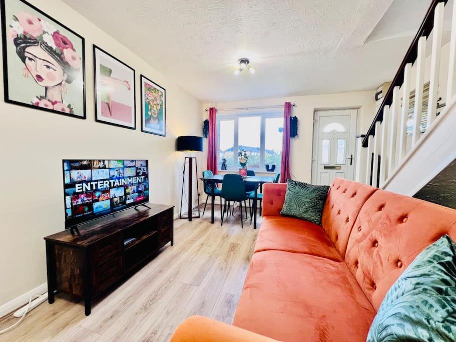a living room with a couch and a television at Brand New! The Cosy Cove by Artisan Stays I Free Parking I Weekly Or Monthly Stay Offer in Chelmsford
