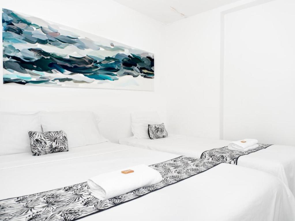- 2 lits avec serviettes et un tableau mural dans l'établissement ALOJAMIENTO MOON, à Valledupar