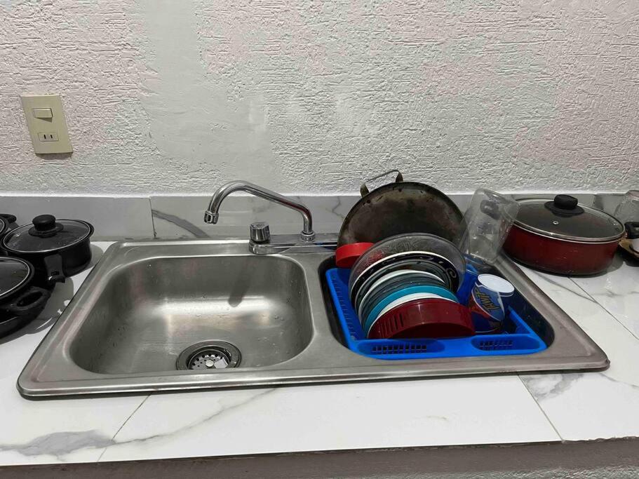 un fregadero de cocina con platos en un drenador de platos en Acogedor Depto 2 Rec. 1 Baño, Cocina Equip en Apatzingán de la Constitución