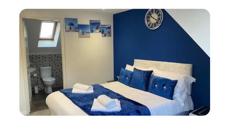 a blue bedroom with a large bed with blue pillows at The Westfield in Liversedge
