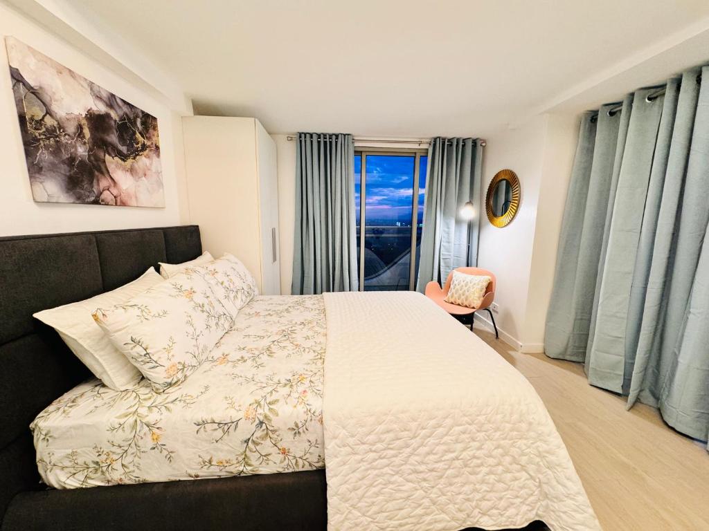 1 dormitorio con cama y ventana en LuxeBali Azure @ Azure North en San Fernando