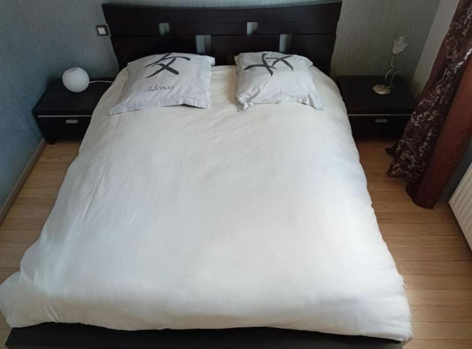 ein großes weißes Bett mit zwei Kissen darauf in der Unterkunft Appartement duplex in Asnières-sur-Seine