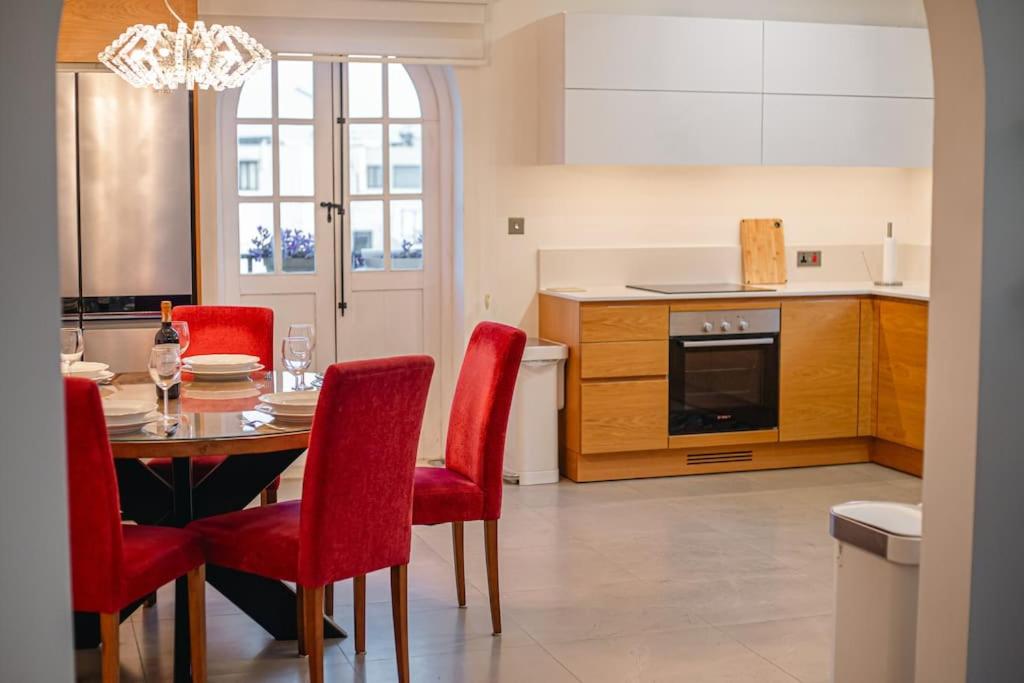 kuchnia ze stołem i czerwonymi krzesłami w obiekcie Lovely 3 bed - Apartment -Sliema w mieście Sliema