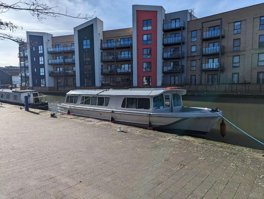 a boat is docked in the water next to buildings at Unique Boat in Chelmsford city in Chelmsford