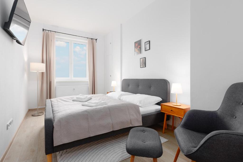 sypialnia z łóżkiem, krzesłem i oknem w obiekcie 2 bedrooms apartment with kitchen near the subway w Pradze