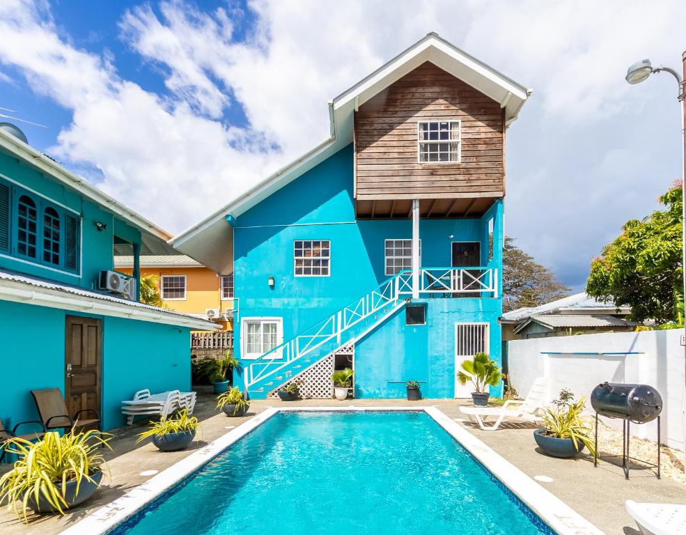 a blue house with a swimming pool in front of it at Beach Studio in Crown Point in Bon Accord