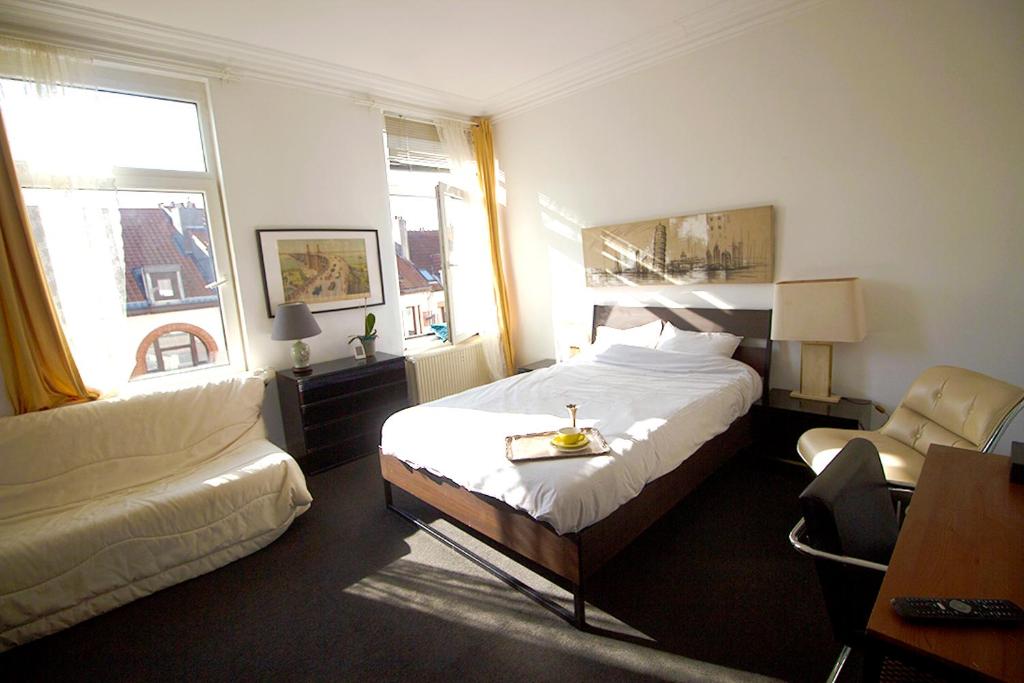 ein Hotelzimmer mit einem Bett und einem Stuhl in der Unterkunft Handy Studio near Nato in Brüssel