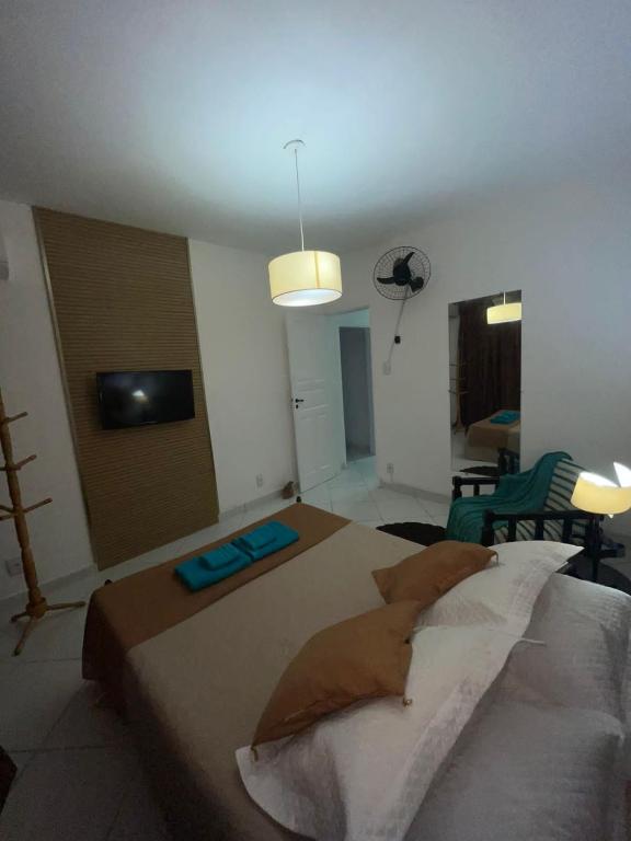 a bedroom with a large bed and a living room at Francisco's House in Angra dos Reis