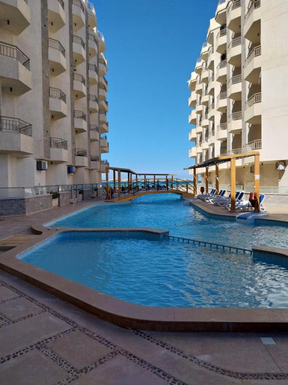 a large swimming pool in the middle of two buildings at La Quinta Heights in Hurghada