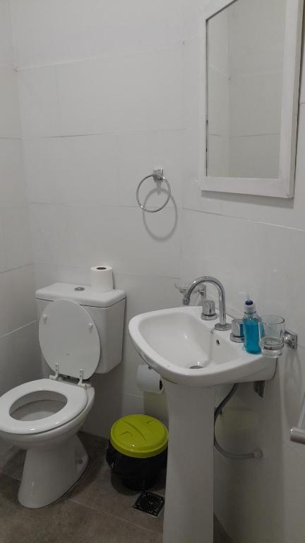 a white bathroom with a toilet and a sink at Amarello in Gualeguaychú