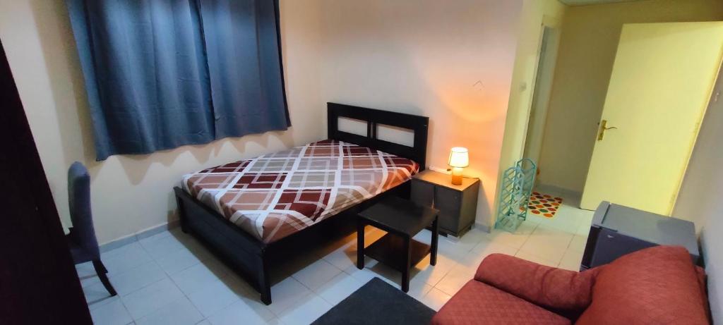 1 dormitorio pequeño con 1 cama y 1 sofá en Cozy Bedroom for Gent, en Sharjah