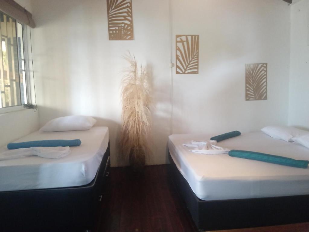 two twin beds in a room with at Casa Yemaya in Necoclí