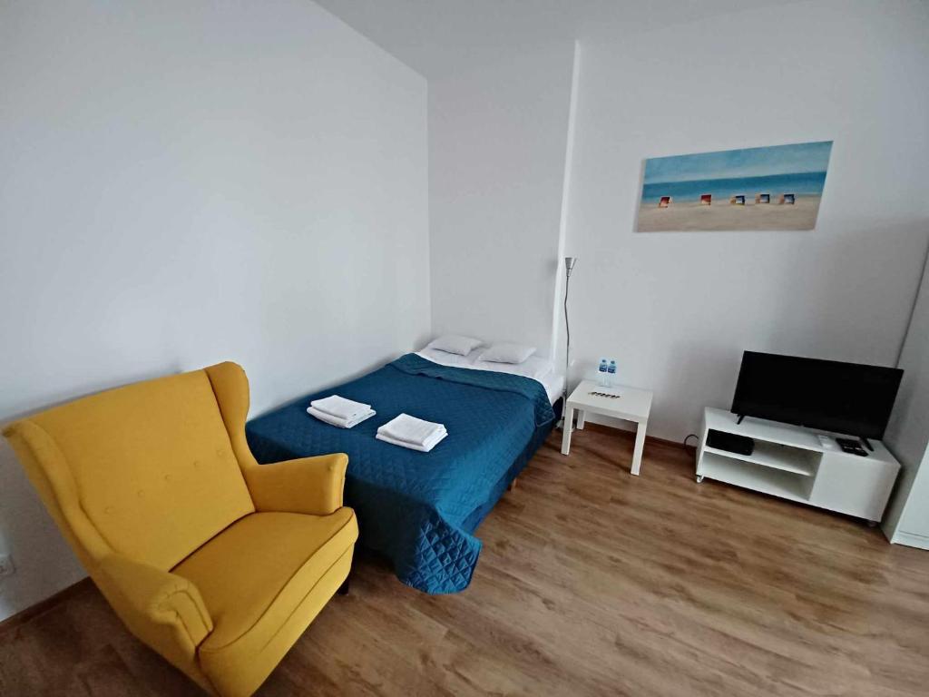 een slaapkamer met een bed, een stoel en een televisie bij Apartament Mona Lisa Sopot in Sopot
