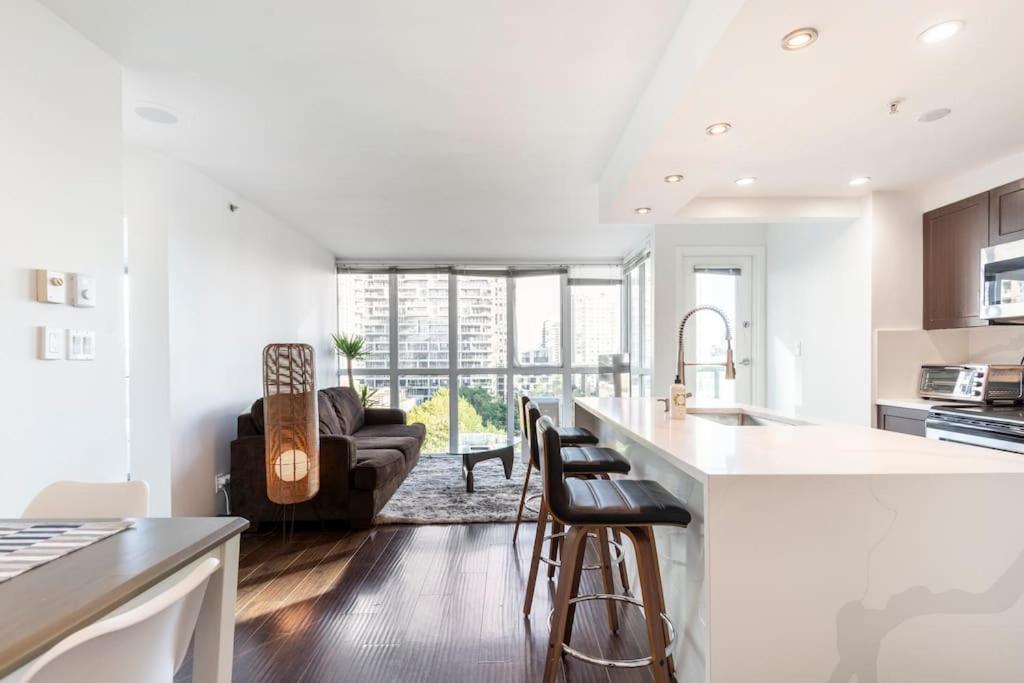 a kitchen and living room with a counter and a couch at Luxury 2-bedroom condo beach side Yaletown in Vancouver