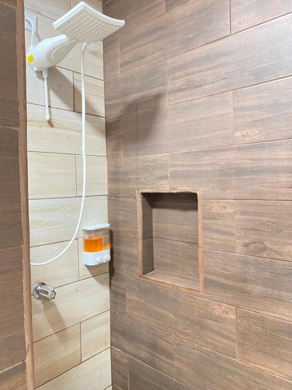 a bathroom with a shower with a wooden wall at Apartamentos H Gonzalez. Wifi A/C free parking in San Rafael