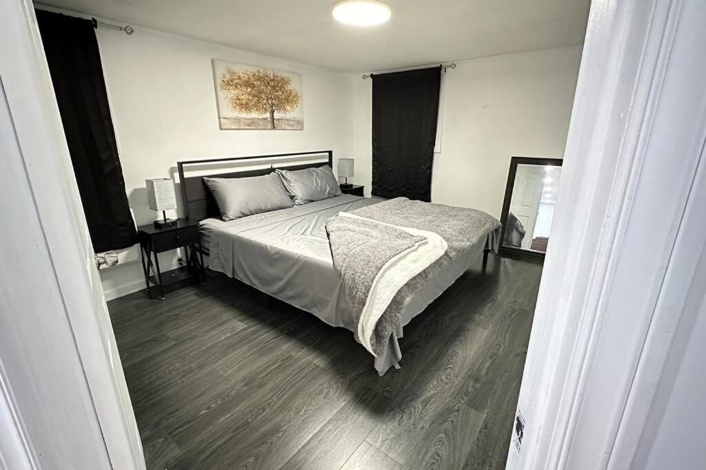 a bedroom with a large bed and a mirror at 2 Bedroom Basement Suite in the heart of Laval in Laval