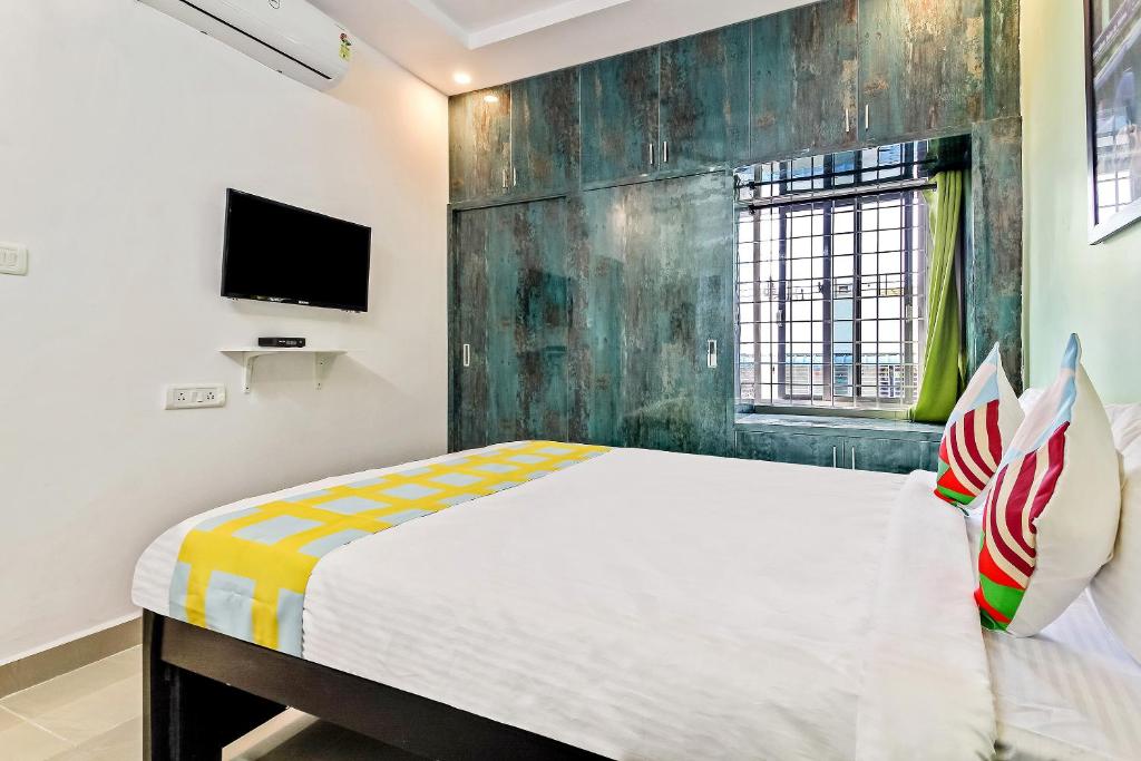 um quarto com uma cama e uma televisão na parede em Collection O Vennela Residency em Lingampalli