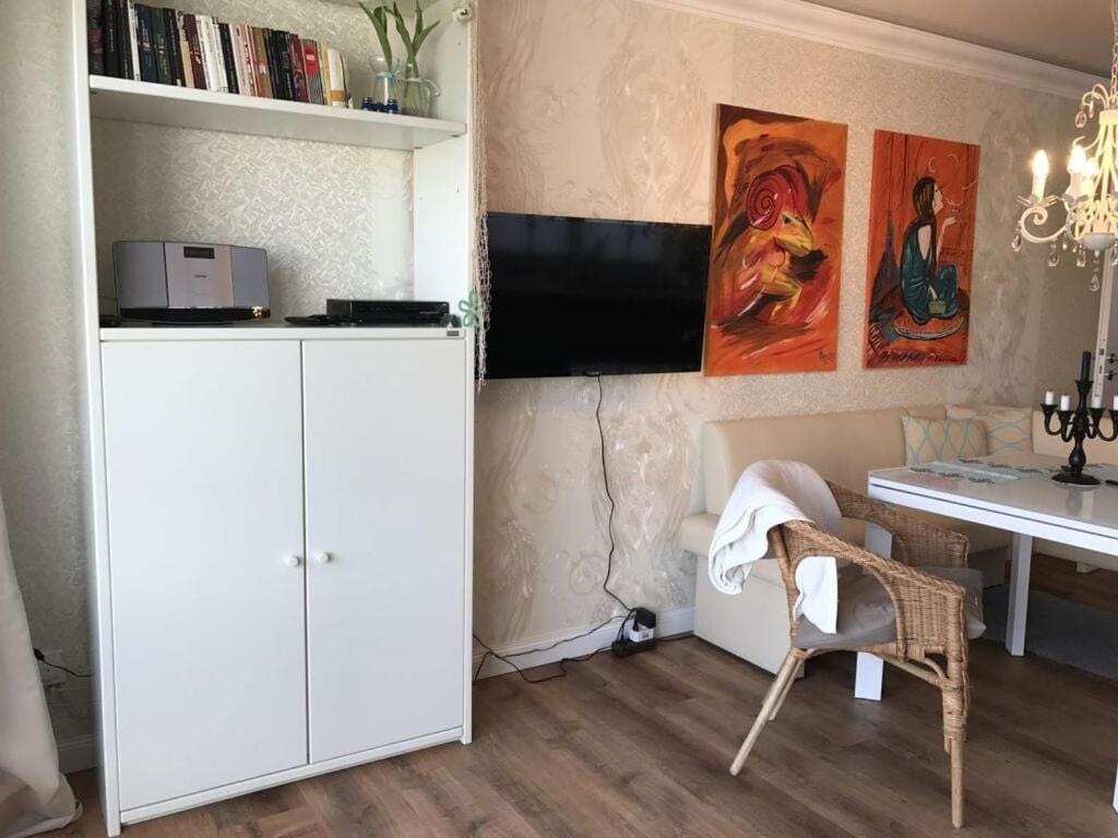 een woonkamer met een bureau en een witte kast bij Holiday apartment in Southern Alps in Haffkrug