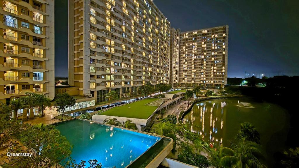 贝克西Trivium Terrace Apartment Lippo Cikarang EJIP -Min Stay 3 Nights-的享有带游泳池的大型建筑的景致