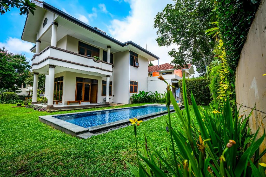 une villa avec une piscine dans une cour dans l'établissement Andaru Graha Puspa For Family and Friends, à Bandung