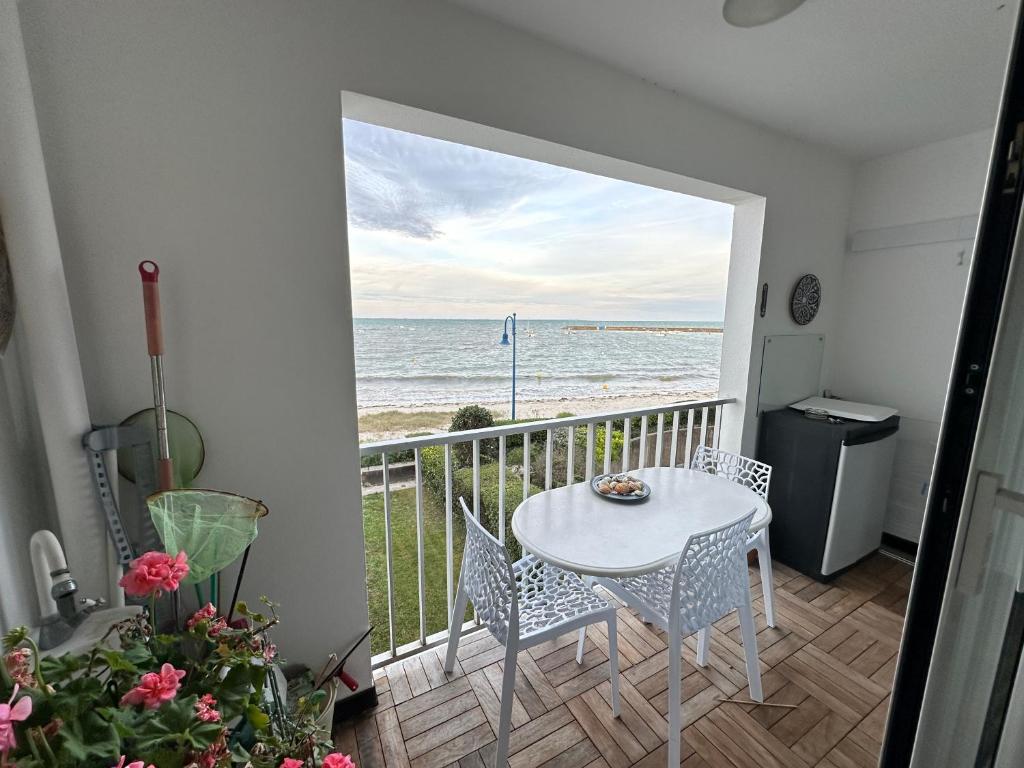 balcón con mesa, sillas y vistas al océano en Ker Lafranec'h - Face Mer et Plage, 2 Chambres, WiFi, en Saint-Pierre-Quiberon