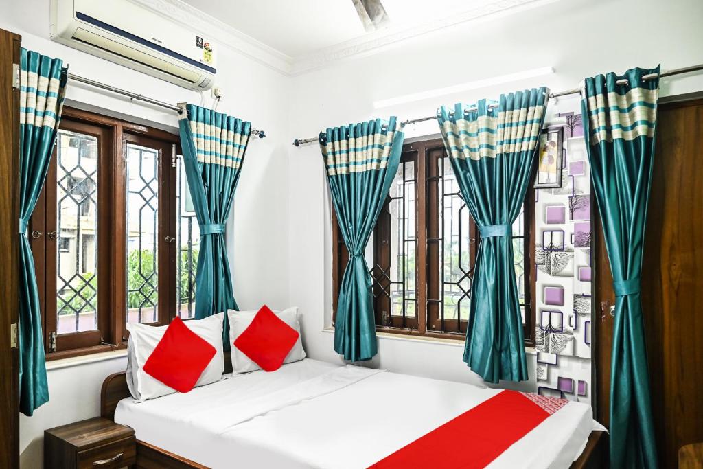a bedroom with a bed with red and blue curtains at OYO Flagship Shraddha Residency 2 in Kolkata