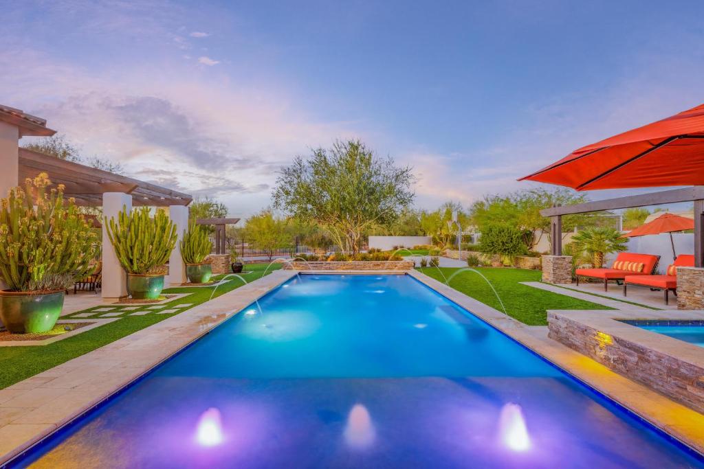 una piscina en un patio con sombrilla en Luxury Estate, Heated Pool, Spa, Game Room, More en Scottsdale