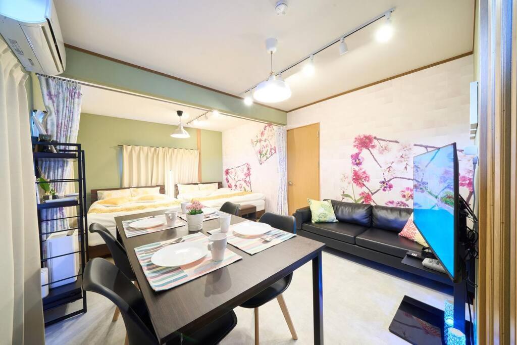 um quarto com uma mesa de jantar e uma sala de estar em 花の宿　別府・鉄輪 em Beppu