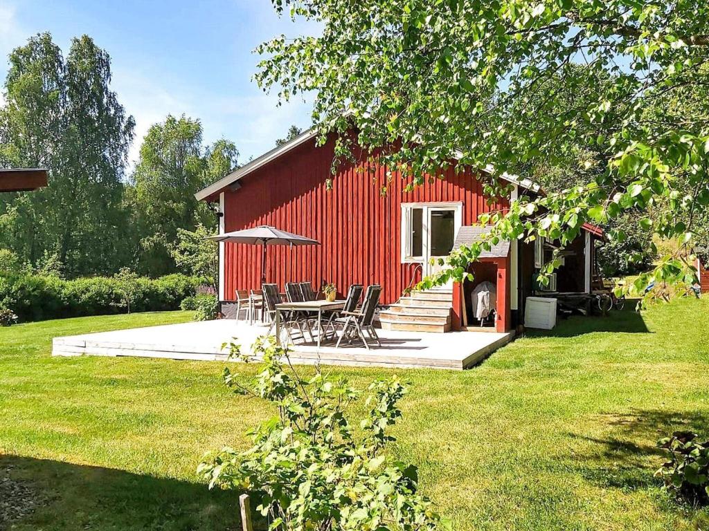 un granero rojo con una mesa y sillas delante en Holiday home ÅBY, en Åby