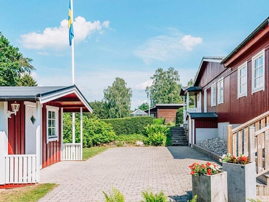 ein rotes Haus mit einer Flagge davor in der Unterkunft Holiday home HÖÖR II in Höör