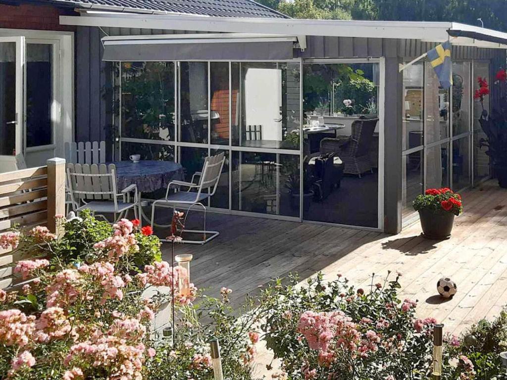 a screened in patio with a table and chairs at Holiday home HÄLLEKIS in Lugnås