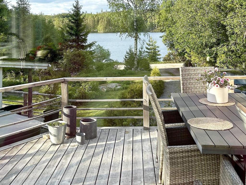 un ponte di legno con un tavolo e una vista sul lago di 4 star holiday home in VINTROSA-By Traum a Vintrosa