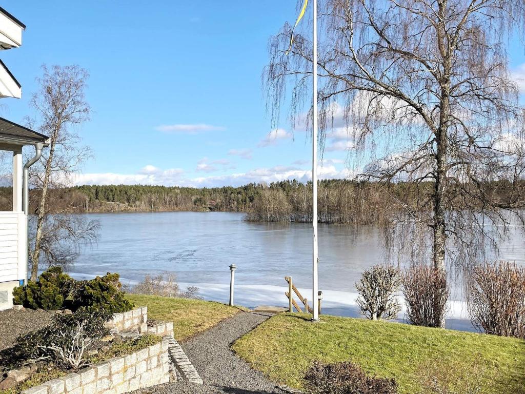 Holiday home Linköping II في لينكوبِنغ: كلب واقف بجانب اطلاله على بحيره