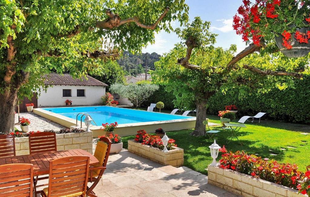 a swimming pool in a yard with chairs and flowers at Le Jardin De So in Barbentane
