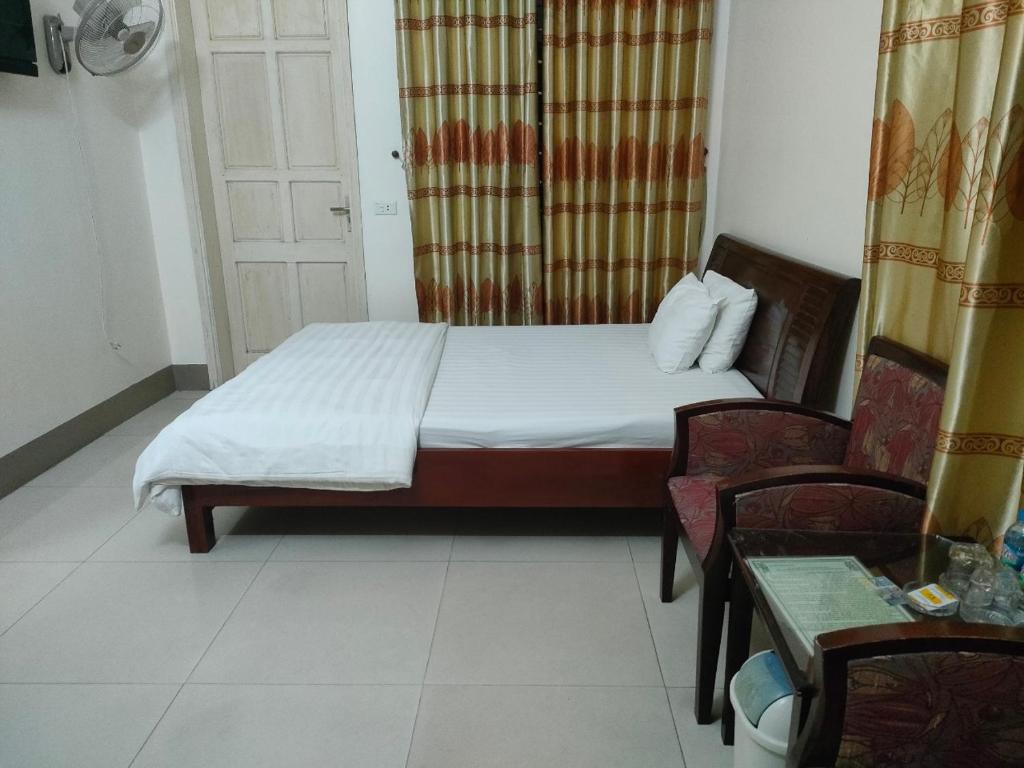 a small bedroom with a bed and a chair at khach san viet uc in Vinh