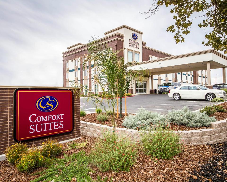 a sign in front of a building with a carport at Comfort Suites Woodland - Sacramento Airport in Woodland