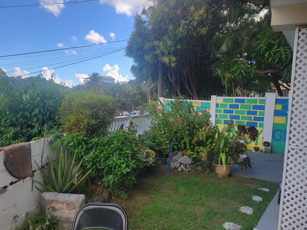 een tuin buiten een huis met planten en een hek bij Exquisite Home away from Home! in Kingstown