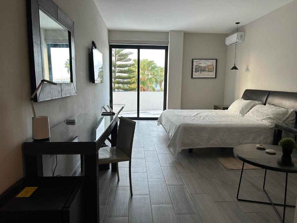 Sala de estar con cama y mesa en Suites Athos4, en Cancún