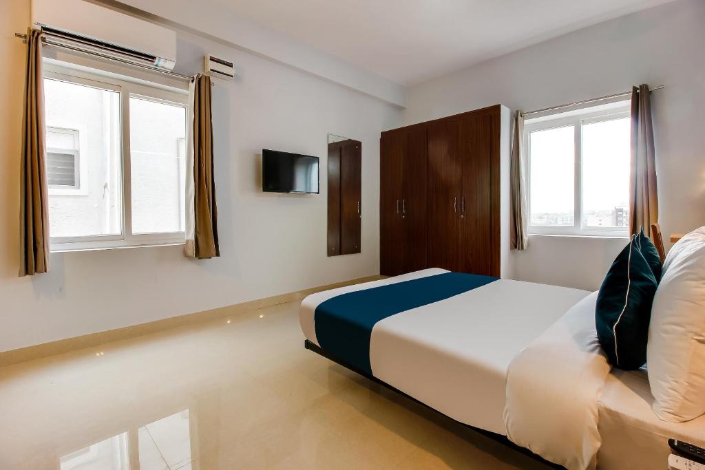 a bedroom with a bed and two windows at OYO SilverKey Oyo Silverkey ,near RTO office kondapur in Kondapur