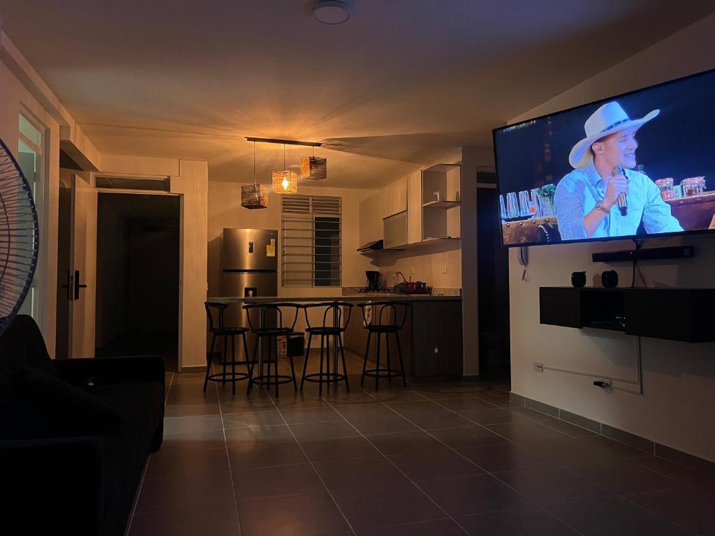 Aqualina Orange Girardot, décimo piso في جيراردو: غرفة معيشة مع تلفزيون بشاشة مسطحة في مطبخ
