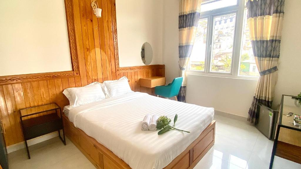 Un dormitorio con una cama con dos zapatos. en Ruby Peace Hotel en Khu Chi Lăng
