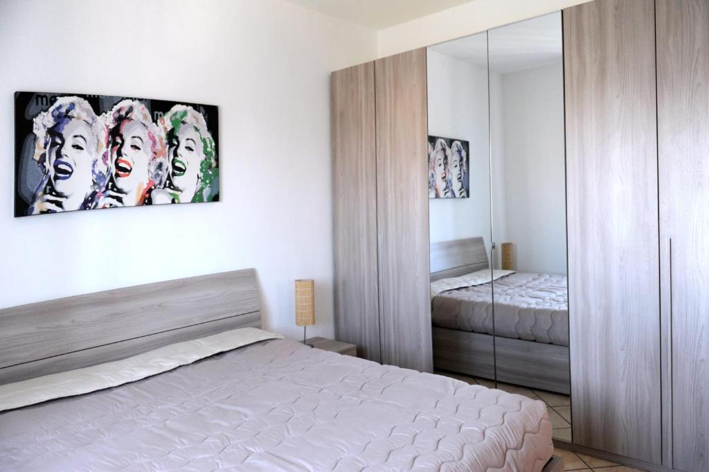 1 dormitorio con cama y espejo en Le Residenze Salentine - Case Vacanza in Lecce, en Lecce