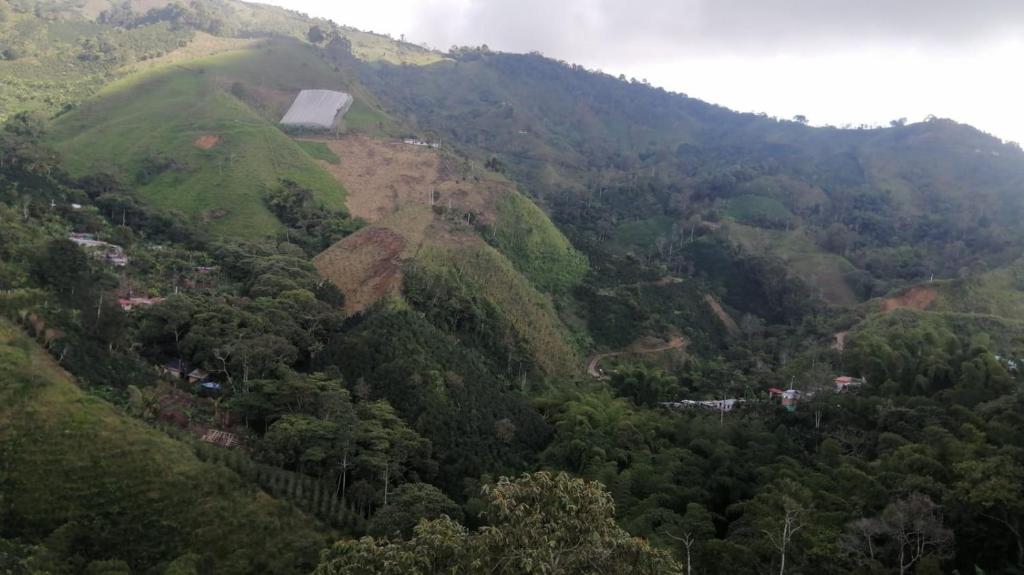 a view of a mountain with a farm on it at Cabaña Natura GREEN in Líbano