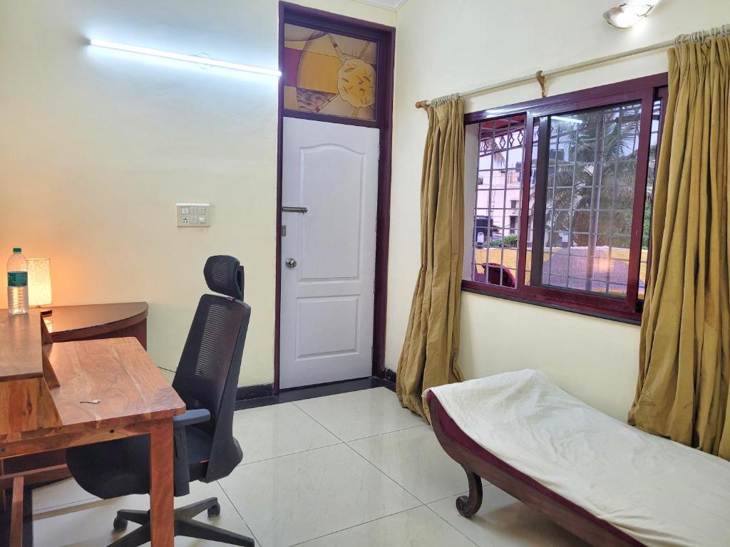 a room with a desk and a bed and a window at Park Breeze Penthouse in Bangalore