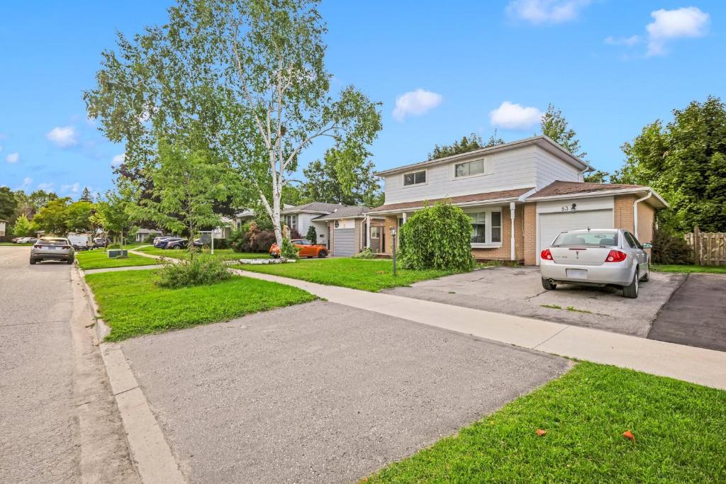 un coche blanco estacionado frente a una casa en Cozy Lower Level 2BR Apartment, en Barrie