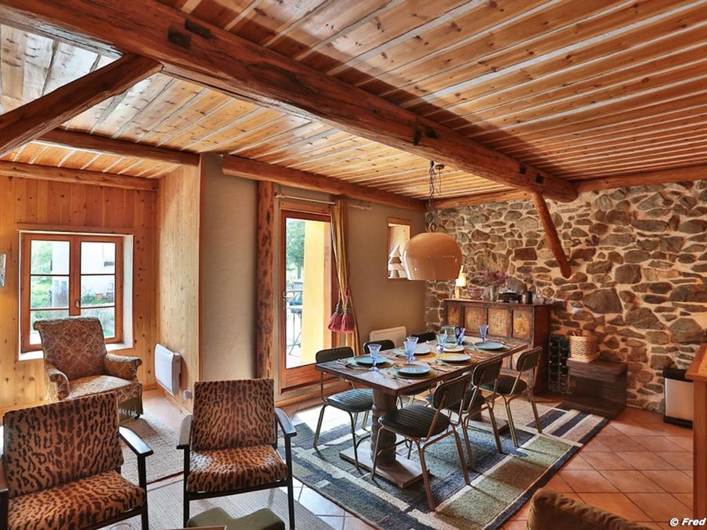 a dining room with a table and chairs and a stone wall at Appartement lumineux 3 pièces – Centre station Serre Chevalier, 4 pers, à 600m des pistes - FR-1-330F-236 in La Salle Les Alpes