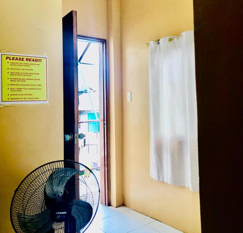 a room with a fan and a door with a window at Wakims INN in Coron