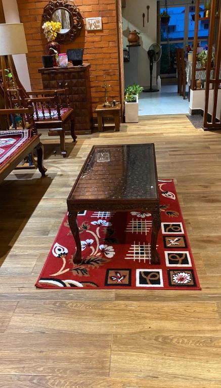 a red rug with a coffee table on a floor at VILLA 359 in Chennai