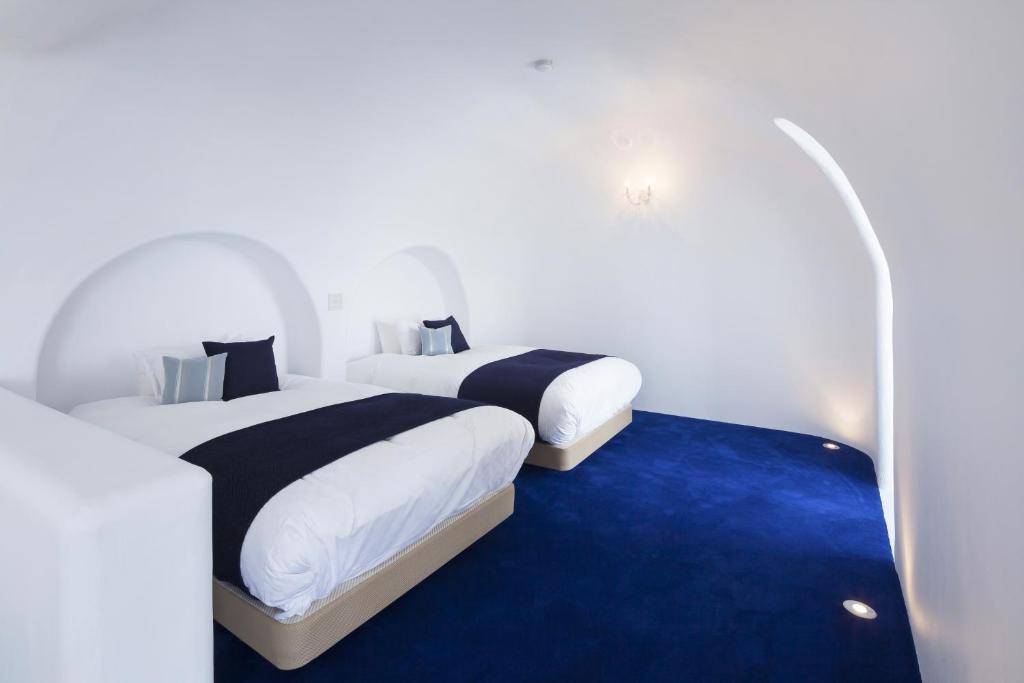 two beds in a room with a blue carpet at Hotel Sea Shell in Shimoda