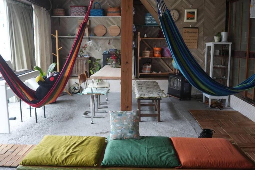 une chambre avec des hamacs dans une chambre avec une table dans l'établissement omusubi guest house (JAPANESE　STYLE）, à Mamihara
